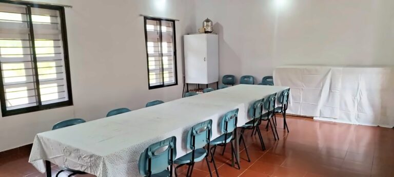 Dining hall with tables and windows looking out to the trees