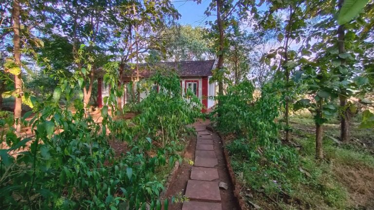 A red-trimmed cottage at the end of a stone path